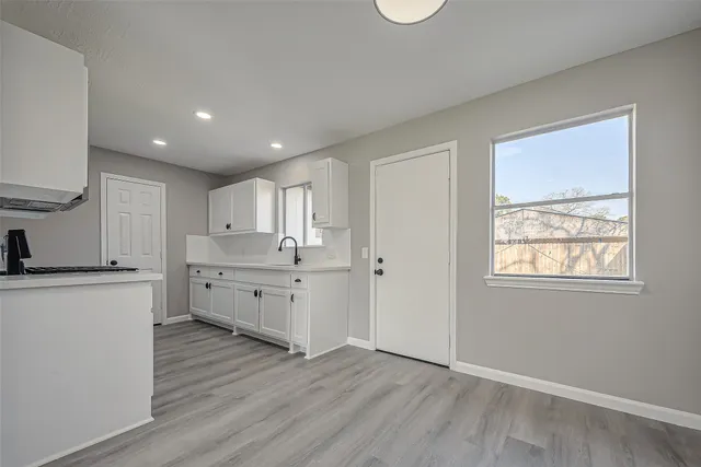 a large kitchen with a wooden floor and a window