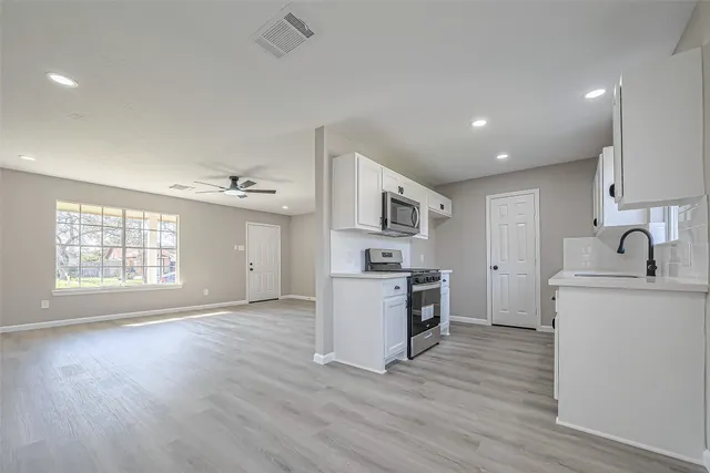 a kitchen with a sink cabinets and wooden floor
