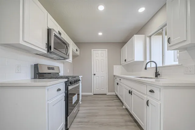 a kitchen with stainless steel appliances granite countertop a sink and cabinets