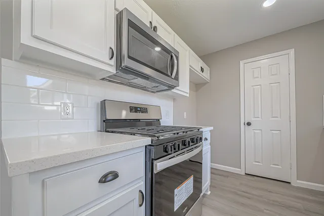 a kitchen with stainless steel appliances granite countertop a stove and a microwave