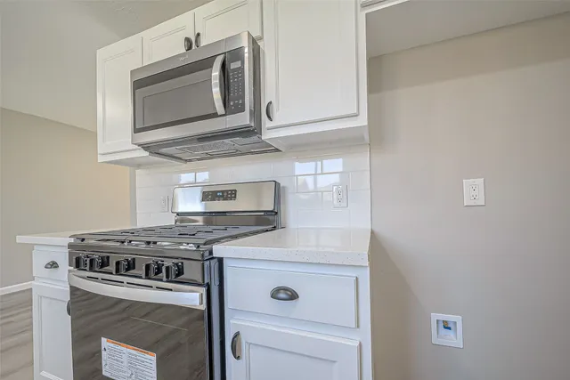 a kitchen with stainless steel appliances granite countertop a stove microwave and oven