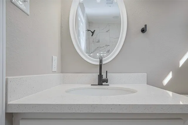 a close view of sink with view of bathroom