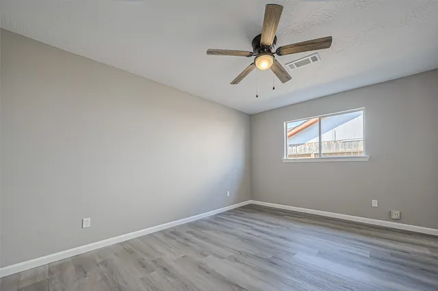 a view of room with wooden floor and ceiling fan