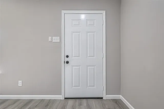 an empty room with wooden floor and closet area