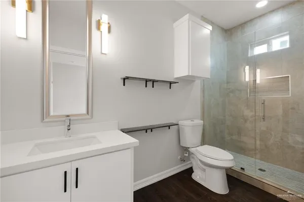 a bathroom with a sink a toilet and shower