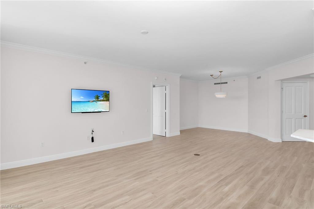 1060 Borghese Lane, Unit 803 Naples, FL 34114 - Photo 15 of 46 Unfurnished living room with light wood-style flooring and crown molding