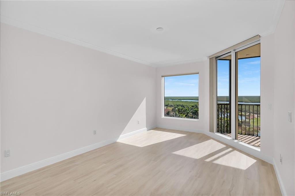 1060 Borghese Lane, Unit 803 Naples, FL 34114 - Photo 17 of 46 Unfurnished room with light wood finished floors, ornamental molding, and a water view