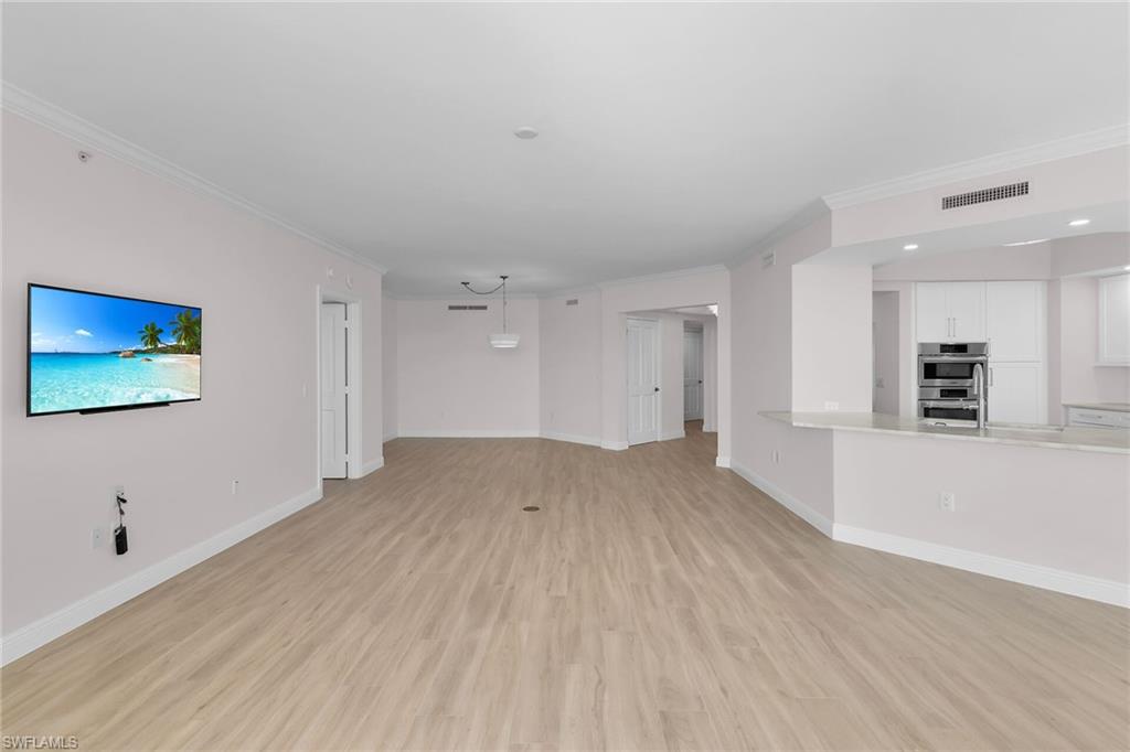 1060 Borghese Lane, Unit 803 Naples, FL 34114 - Photo 19 of 46 Unfurnished living room with crown molding, light wood-style floors, and recessed lighting