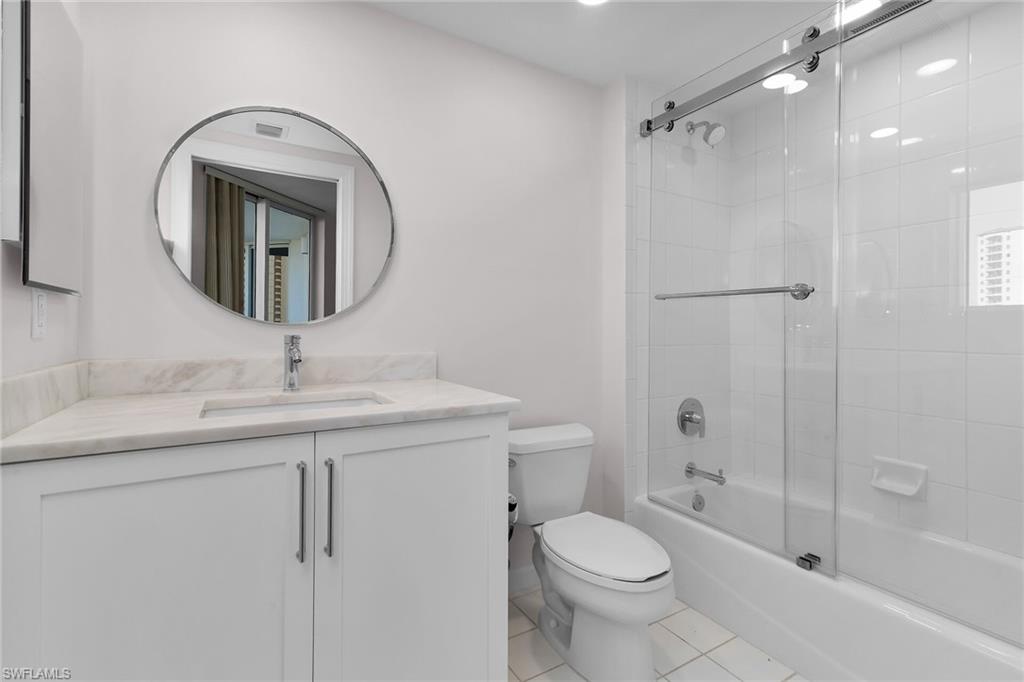 1060 Borghese Lane, Unit 803 Naples, FL 34114 - Photo 22 of 46 Full bathroom with bath / shower combo with glass door, light tile patterned floors, and vanity