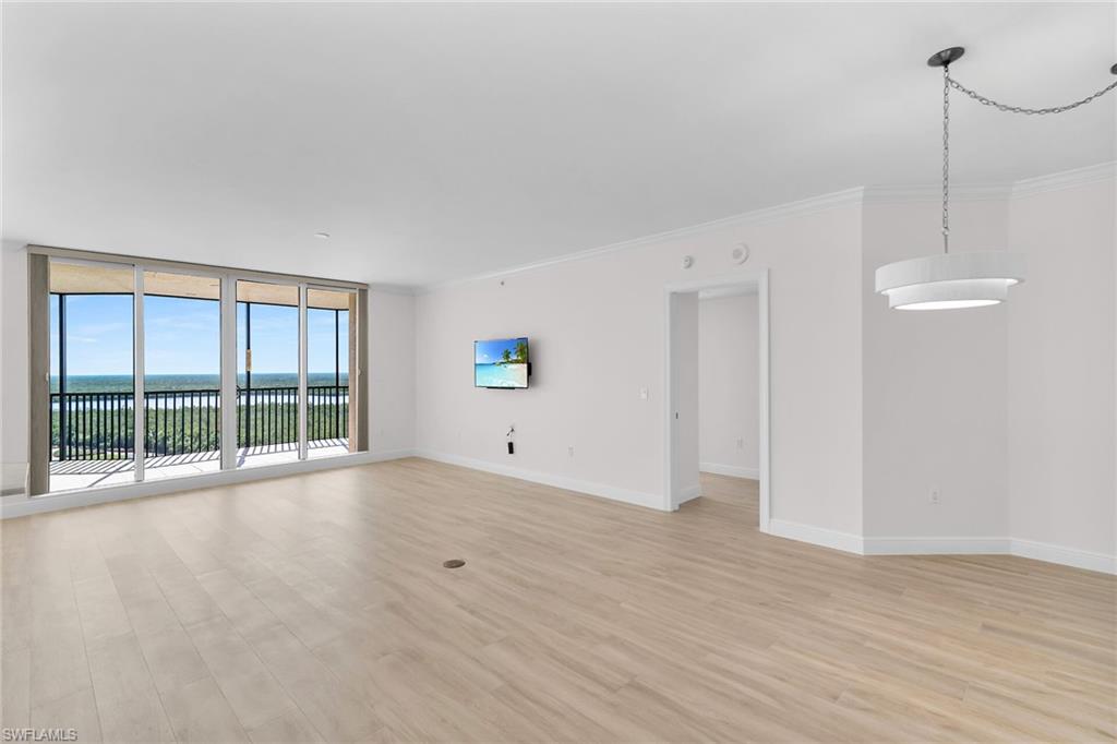 1060 Borghese Lane, Unit 803 Naples, FL 34114 - Photo 10 of 46 Unfurnished living room featuring light wood-type flooring, crown molding, and floor to ceiling windows