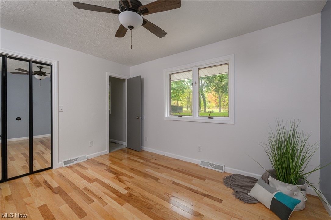279 South Messner Road New Franklin, OH 44319 - Photo 12 of 30 Unfurnished bedroom featuring a closet, ceiling fan, a textured ceiling, and light hardwood / wood-style flooring