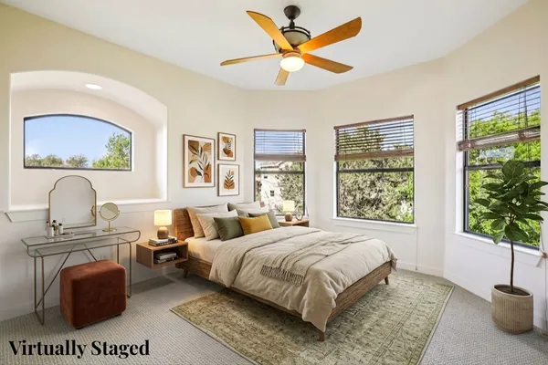 a bedroom with a bed a chandelier and a window