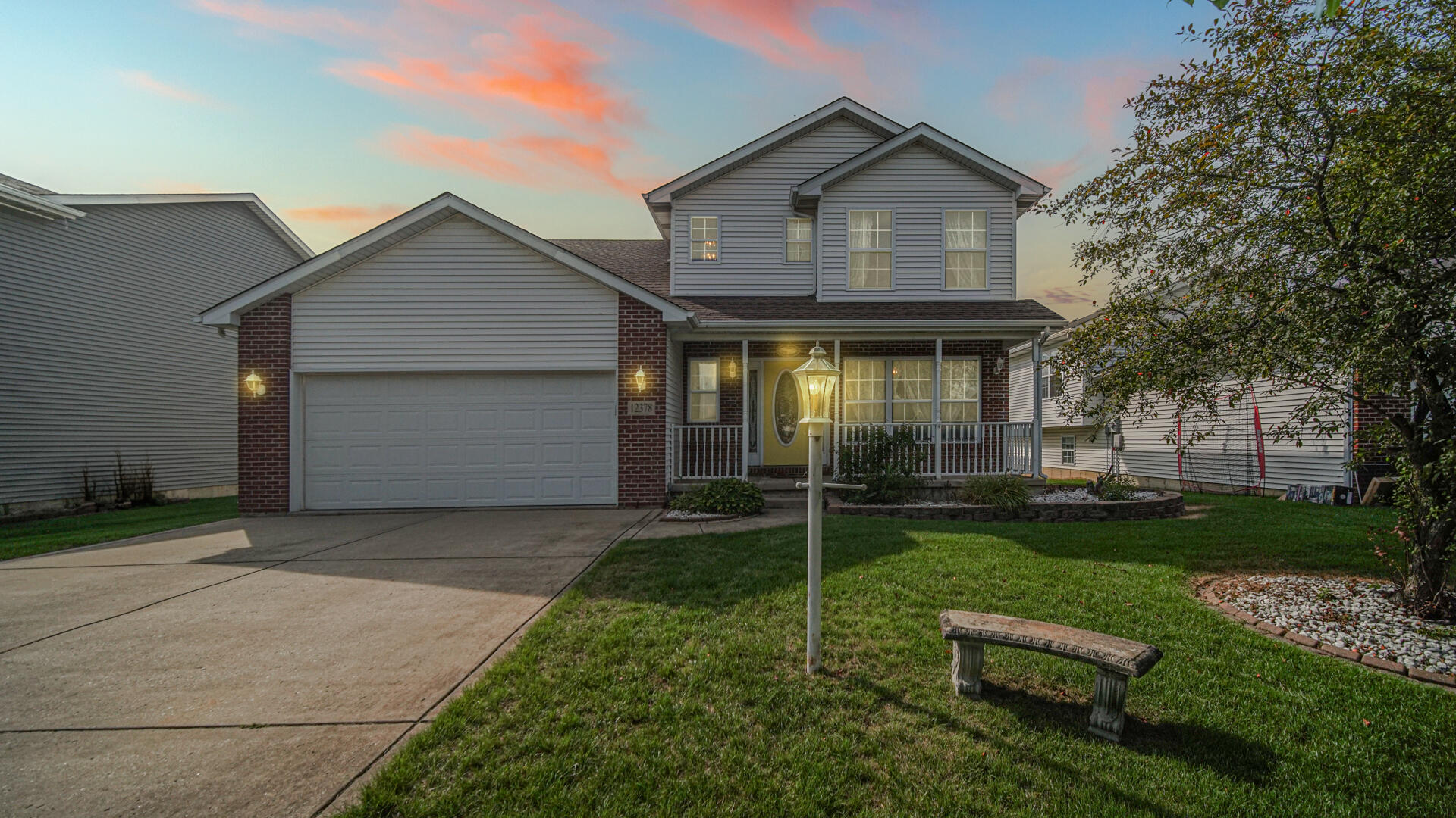 a front view of a house with plants and garden