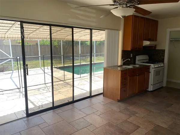 a kitchen with stainless steel appliances granite countertop a stove a sink and dishwasher with a large window