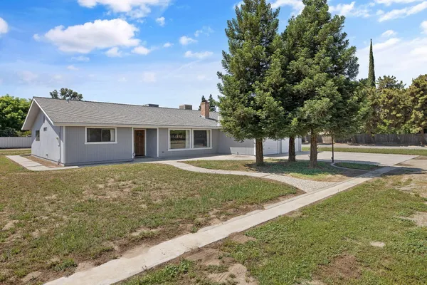 a view of a house with backyard and trees