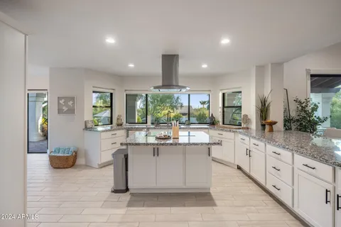 a kitchen with stainless steel appliances a white refrigerator a stove a microwave and cabinets