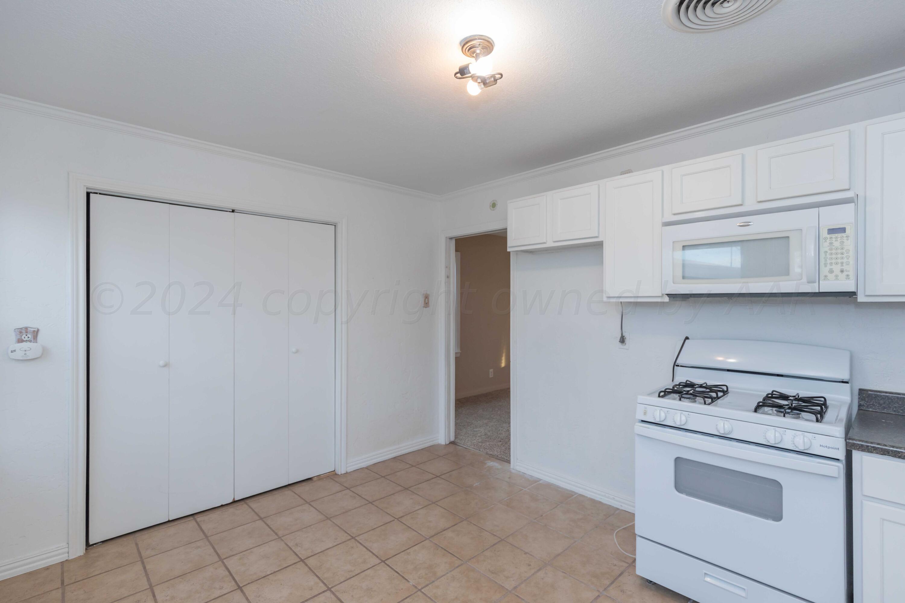 4318 South Monroe Street Amarillo, TX 79110 - Photo 14 of 36 a kitchen with white cabinets and white appliances