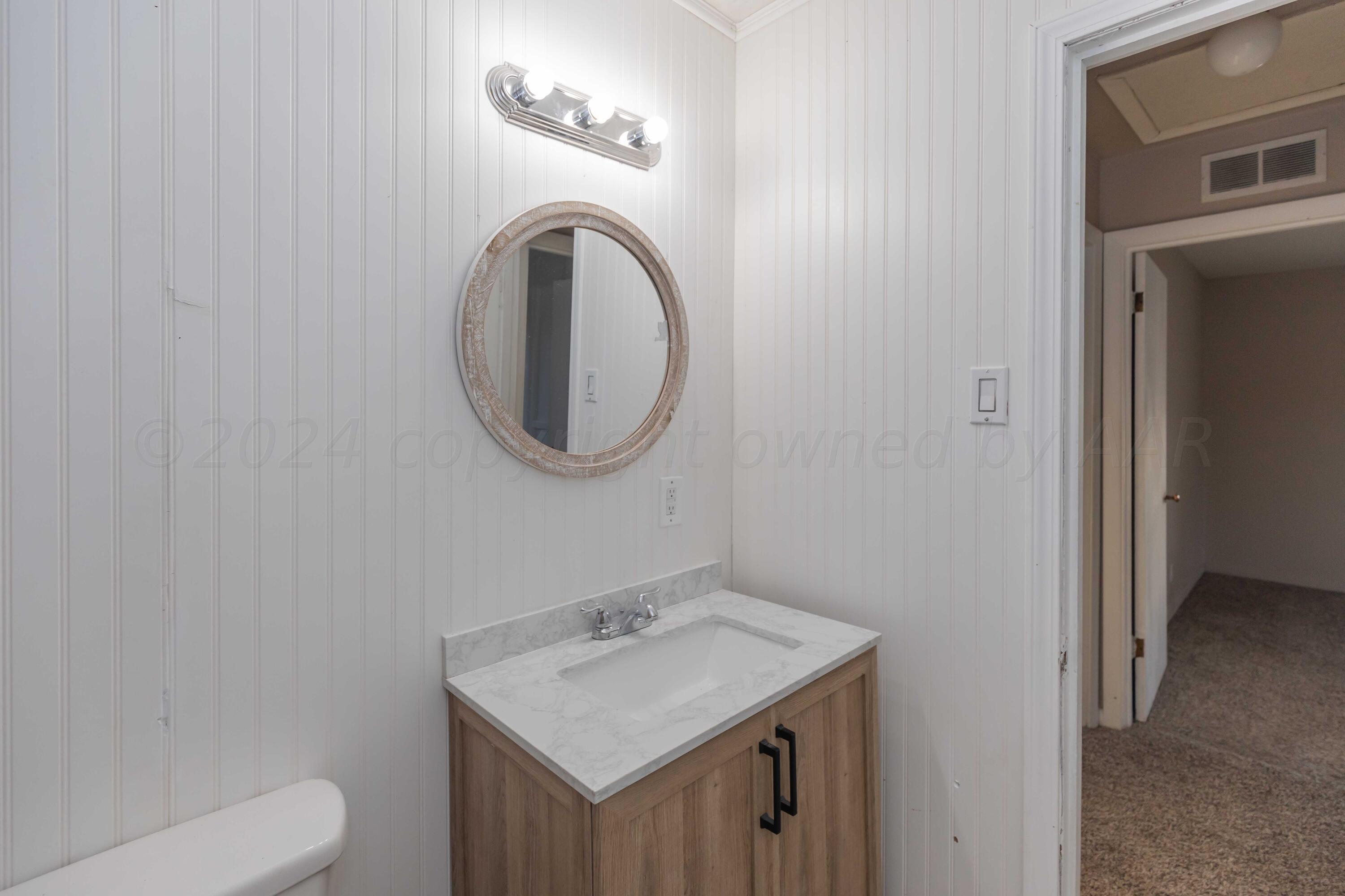 4318 South Monroe Street Amarillo, TX 79110 - Photo 21 of 36 a bathroom with a sink a mirror and a toilet