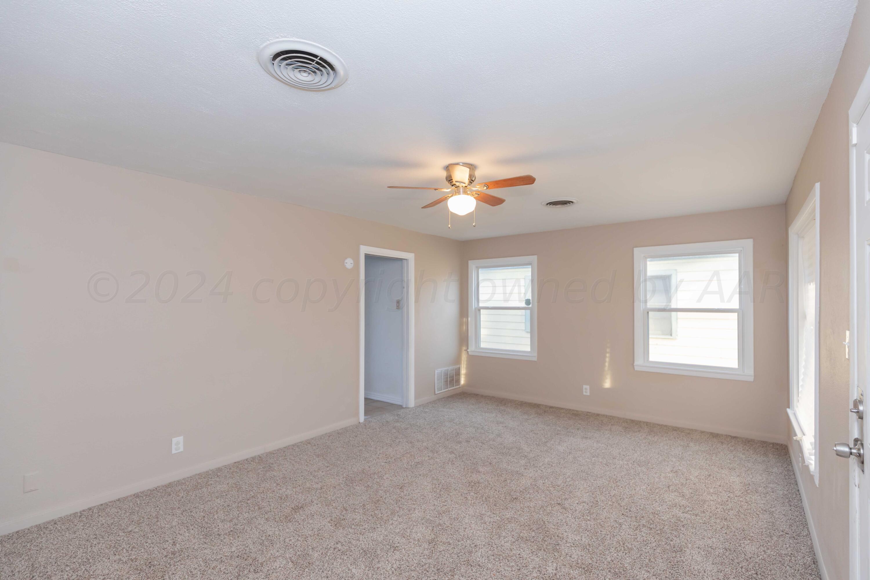 4318 South Monroe Street Amarillo, TX 79110 - Photo 8 of 36 an empty room with windows and chandelier fan