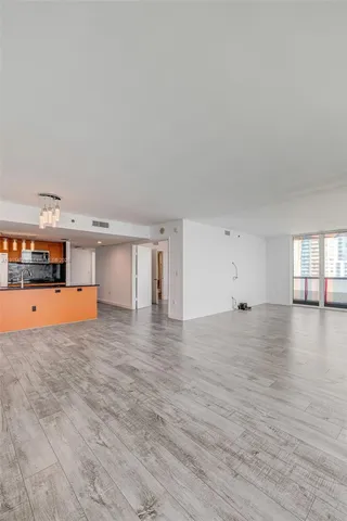 a view of empty room with wooden floor and window