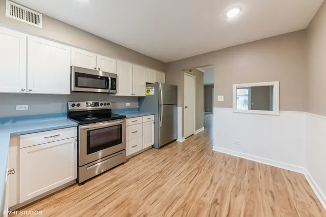 a kitchen with granite countertop a refrigerator stove top oven and sink