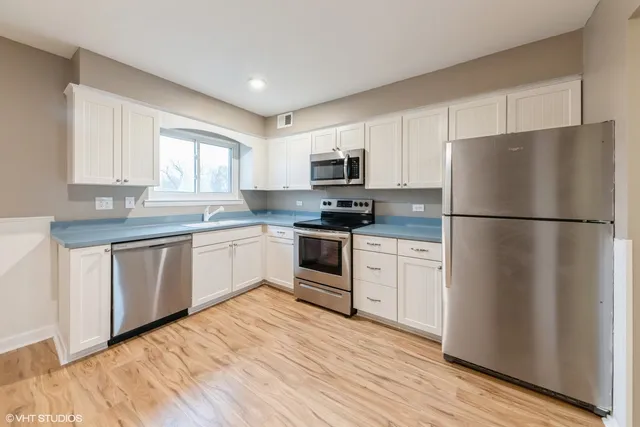 a kitchen with a refrigerator stove top oven and cabinets