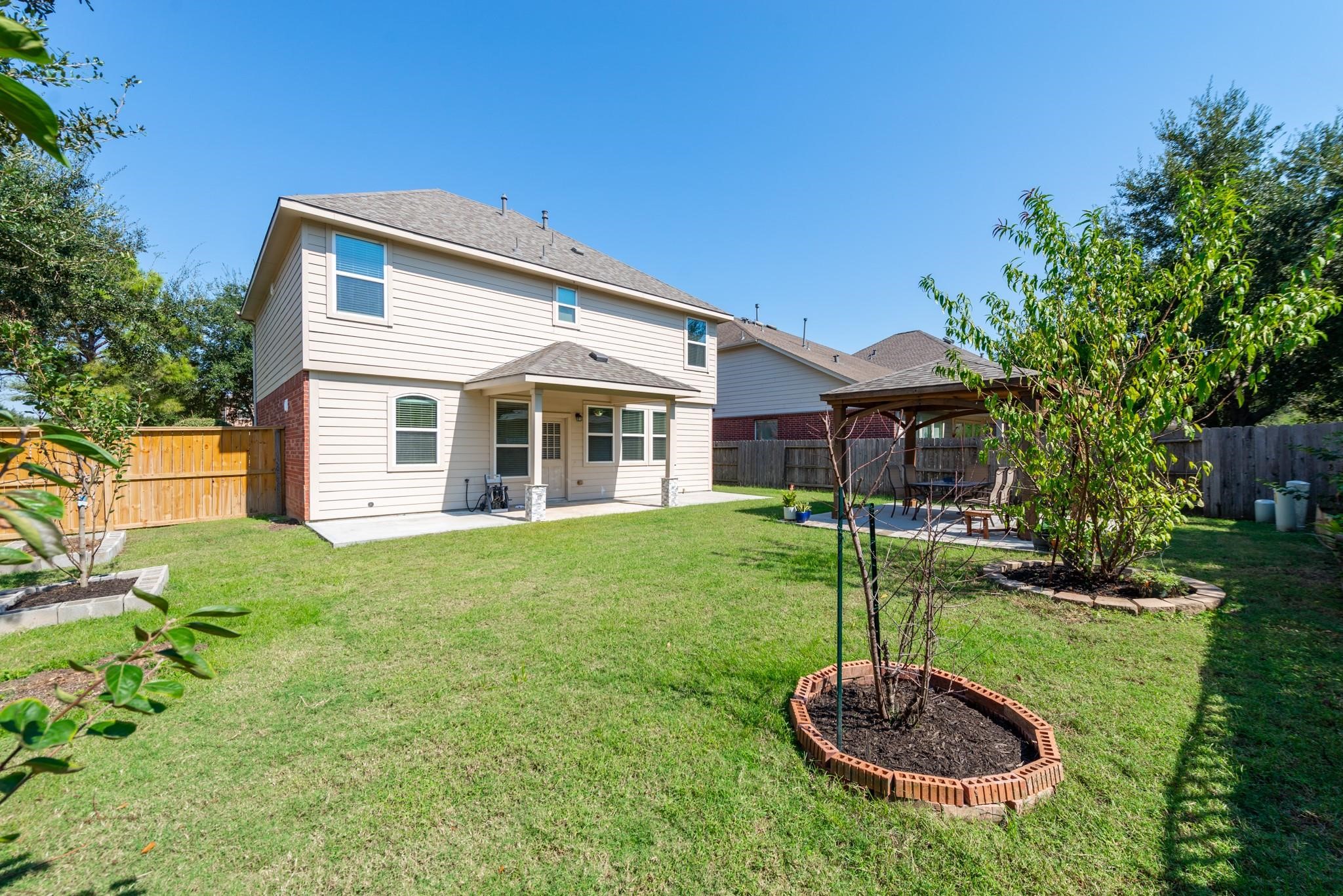 6402 Addlestone Ridge Lane Katy, TX 77494 - Photo 23 of 25 Expansive fenced backyard offers plenty of room for outdoor activities, gardening, pets, or simply enjoying the outdoors. The covered patio and custom pergola create multiple spaces for entertaining and relaxation, while included lawn maintenance means you can enjoy the yard without the upkeep.