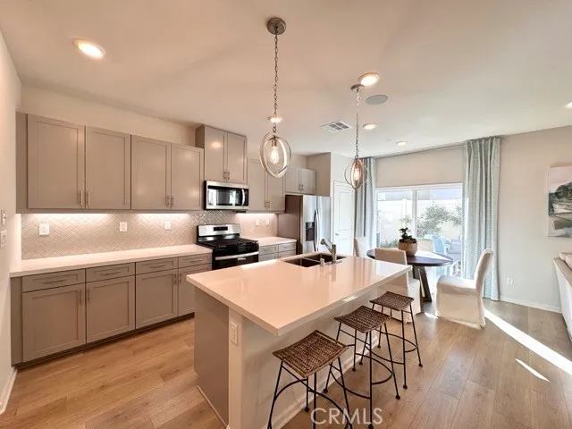 a kitchen with sink a refrigerator and chairs