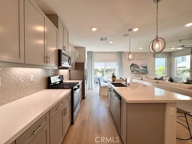 a kitchen with kitchen island granite countertop a sink a counter space and stainless steel appliances