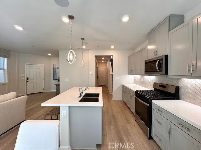 a kitchen with a sink a stove and chairs