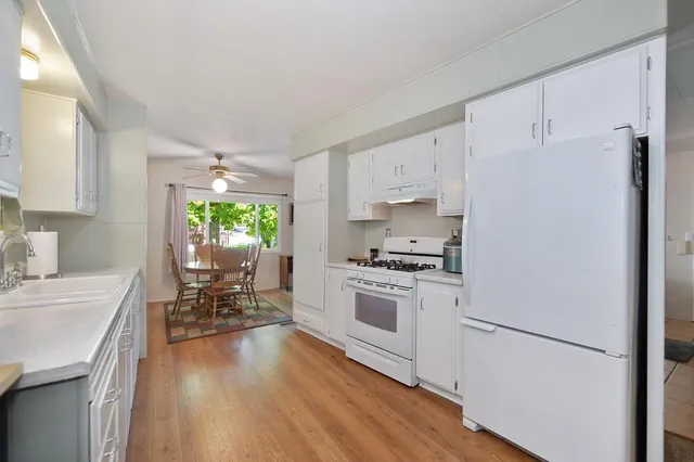 a kitchen with granite countertop a stove a sink dishwasher and a refrigerator