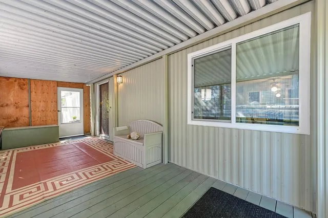 a view of a bedroom with wooden floor and windows