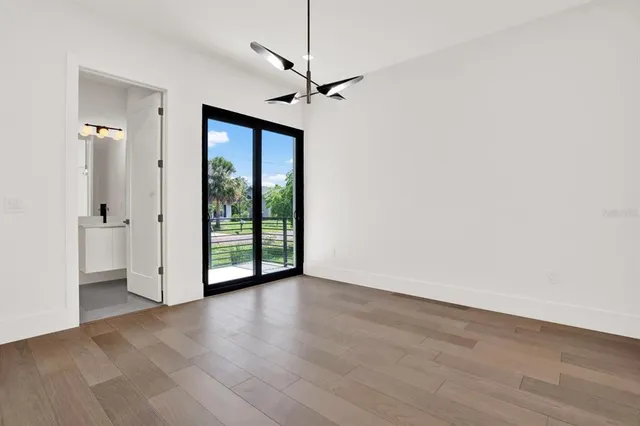a view of a livingroom with wooden floor a ceiling fan and windows