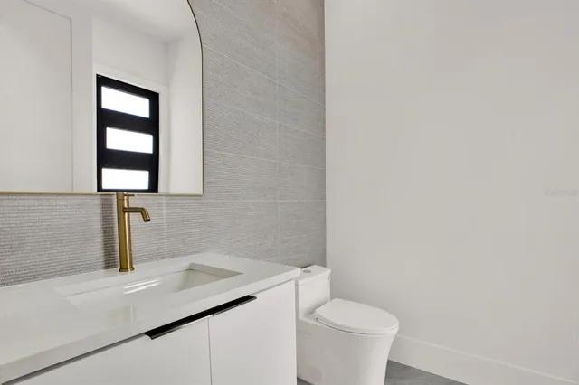 a bathroom with a toilet sink and mirror