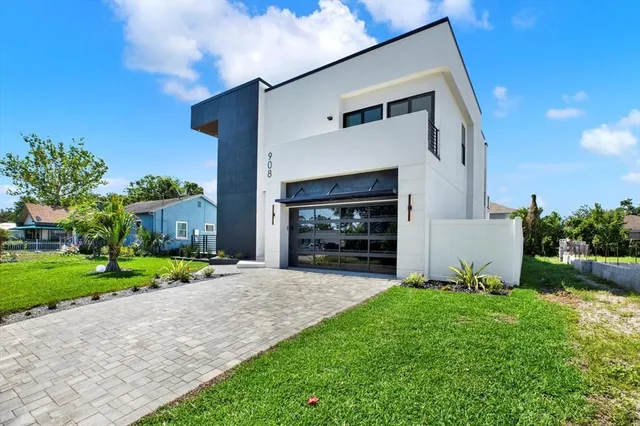 a view of a house with a yard and potted plants