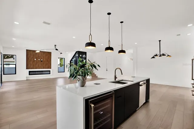 a kitchen with stainless steel appliances granite countertop a sink and a wooden floor