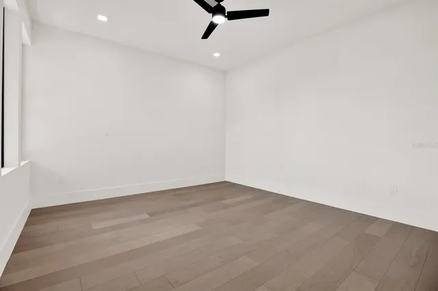 an empty room with a ceiling fan and window