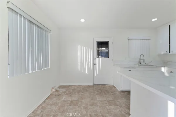 a kitchen with white cabinets and white appliances