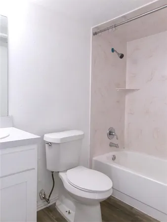 a white toilet sitting next to a bath tub