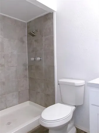 a white toilet sitting next to a bath tub and a shower