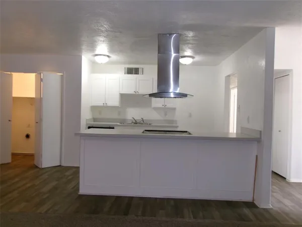 a kitchen with stainless steel appliances granite countertop a sink a stove and a wooden floors