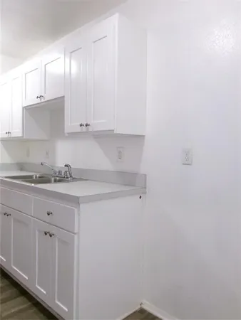 a kitchen with granite countertop white cabinets and a sink