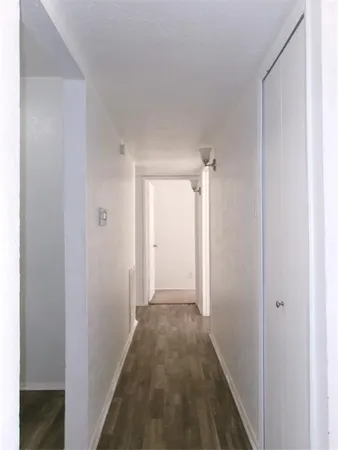 a view of hallway with closet and a white door