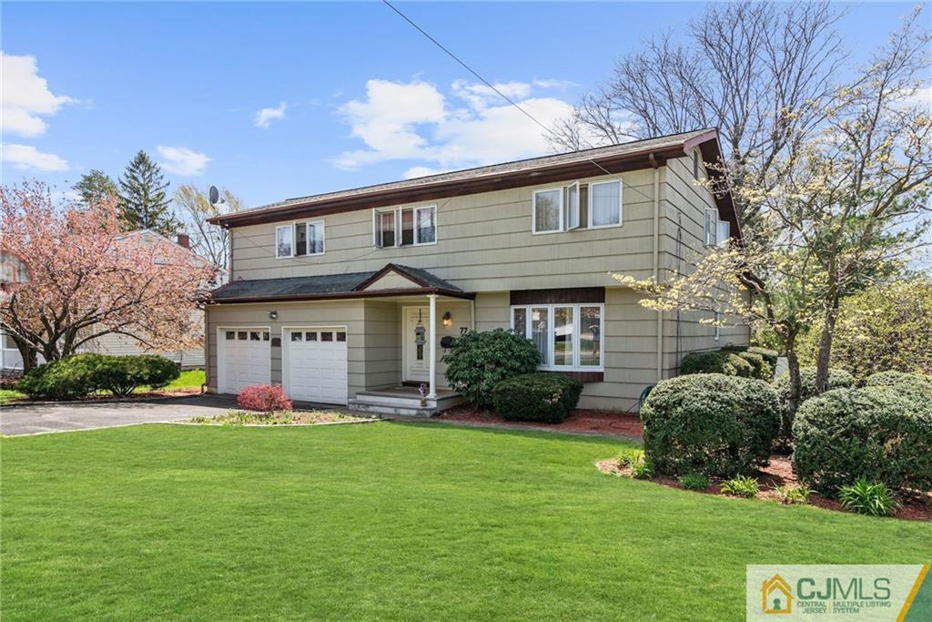 77 Rolling Hills Road Clifton, NJ 07013 - Photo 14 of 16 a front view of a house with a yard and garage