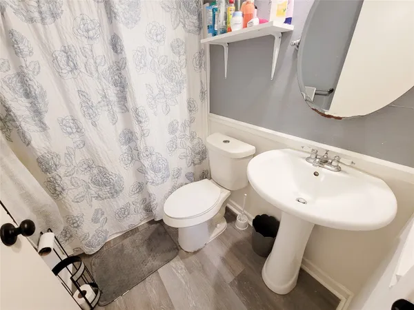 a bathroom with a toilet sink and mirror