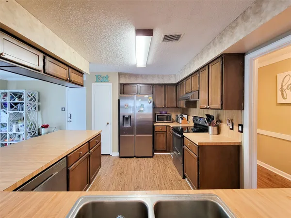 a kitchen with a sink stove and refrigerator
