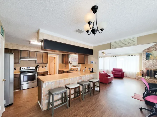 a living room with kitchen island furniture and a chandelier
