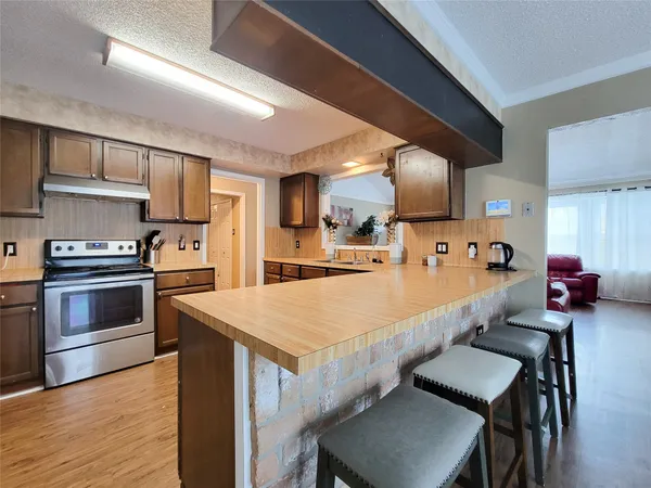 a large kitchen with a table chairs and a wooden floor