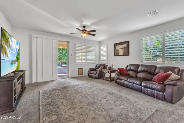 a living room with furniture a window and a flat screen tv