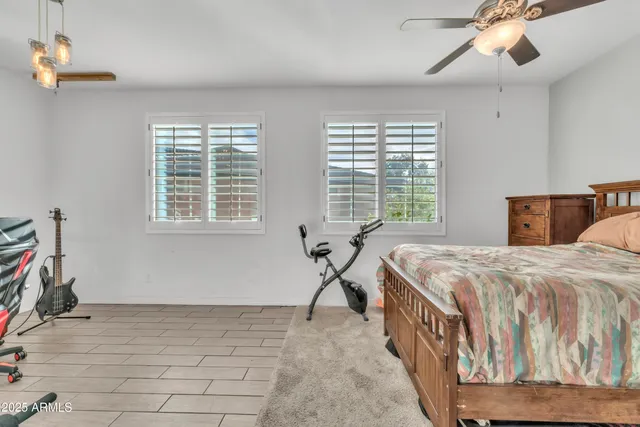 a bedroom with a bed a dresser and a window